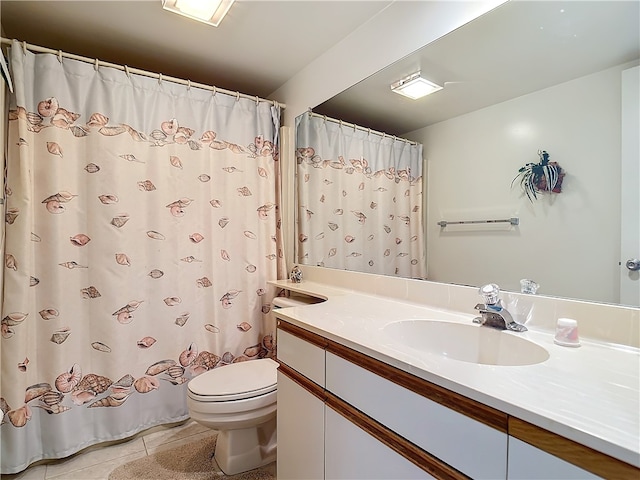 bathroom with toilet, vanity, and tile patterned floors