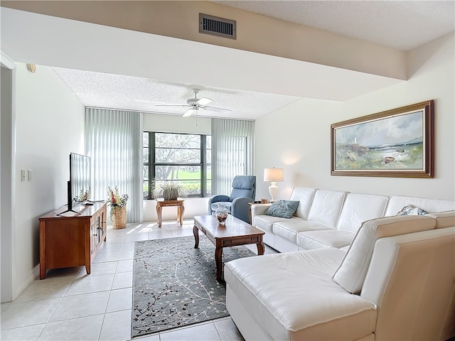 tiled living room with a textured ceiling and ceiling fan