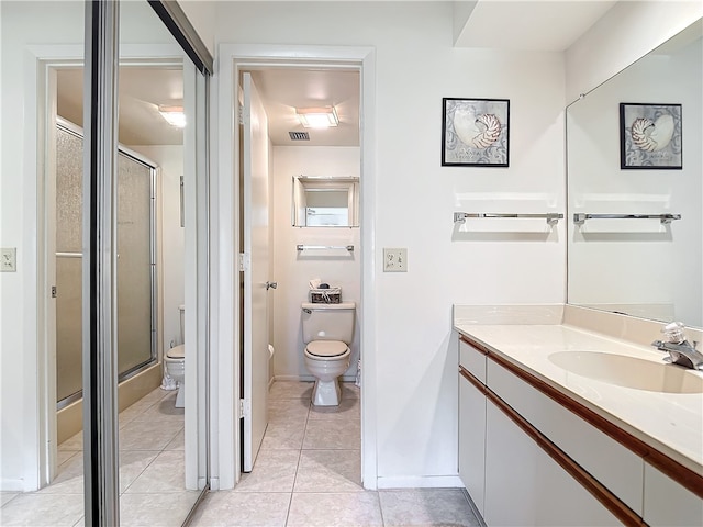 bathroom with tile patterned flooring, an enclosed shower, vanity, and toilet