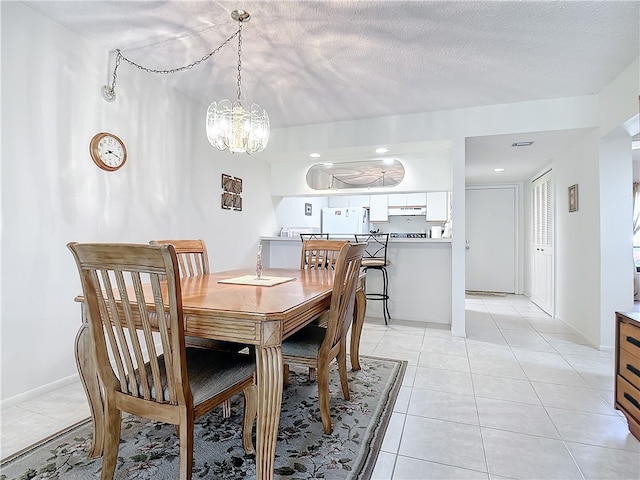 tiled dining room featuring a textured ceiling and a notable chandelier