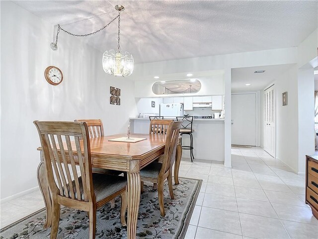 32 Plantation Dr Unit 102, Vero Beach, FL 32966 - dining area featuring a chandelier, light tile patterned flooring, and baseboards