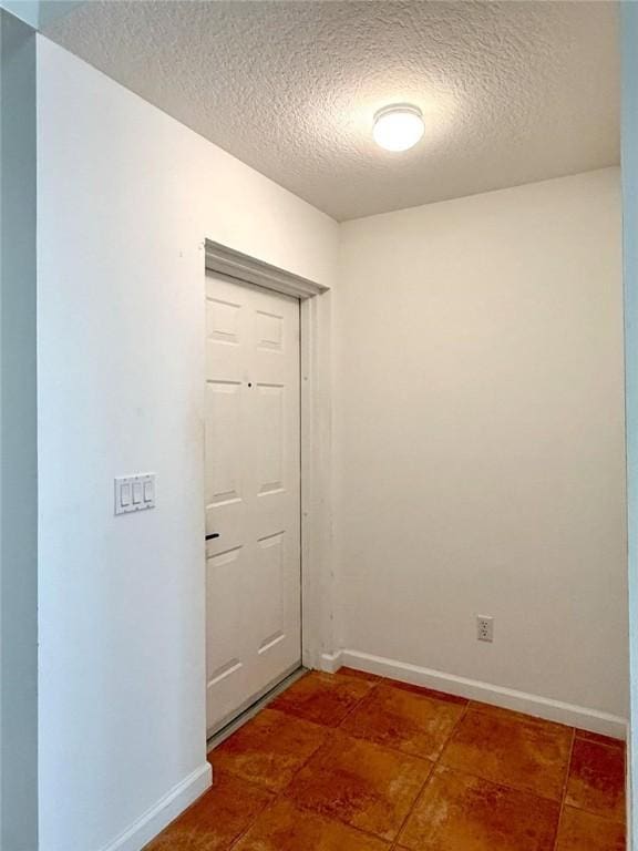 500 7th Pl Unit 102, Vero Beach, FL 32962 - tiled empty room with a textured ceiling and baseboards