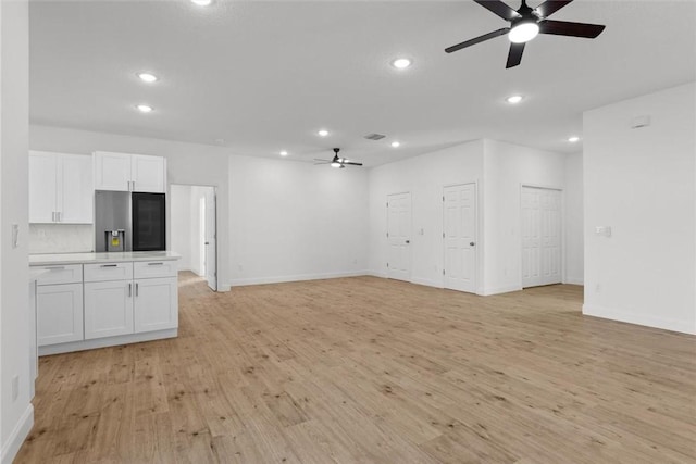 unfurnished living room with ceiling fan and light wood-type flooring