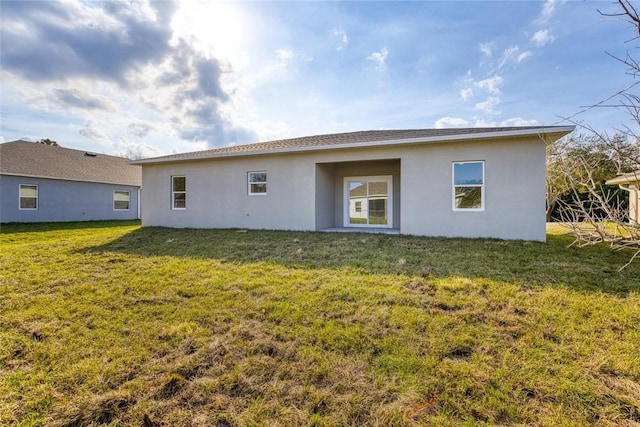 rear view of property featuring a lawn