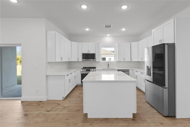 kitchen featuring a kitchen island, white cabinetry, and appliances with stainless steel finishes