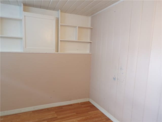 empty room with wooden walls and wood-type flooring