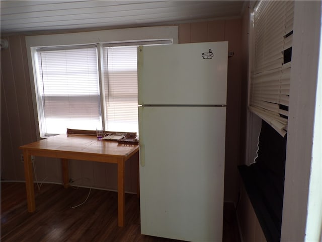 kitchen with white fridge, tile counters, wood walls, and dark hardwood / wood-style floors