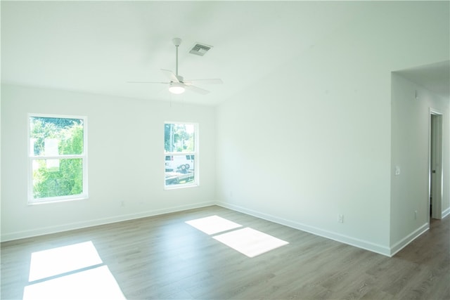 unfurnished room with hardwood / wood-style flooring, a healthy amount of sunlight, and ceiling fan