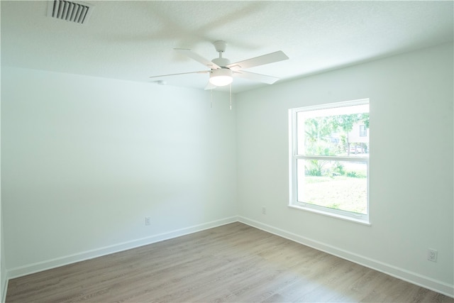 unfurnished room with ceiling fan, a textured ceiling, and light hardwood / wood-style flooring