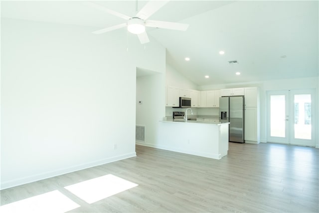 unfurnished living room featuring light wood-type flooring, sink, and high vaulted ceiling