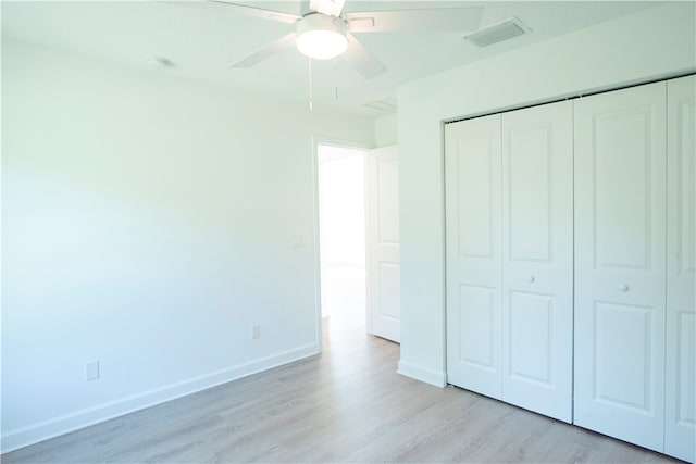 unfurnished bedroom featuring a closet, light wood-type flooring, and ceiling fan