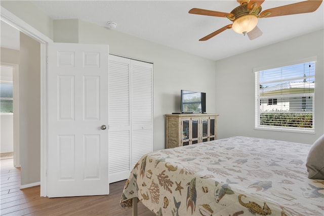 bedroom with hardwood / wood-style flooring, ceiling fan, and a closet