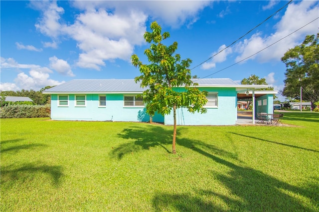 rear view of property featuring a patio and a yard