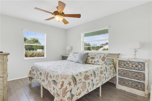 bedroom with dark hardwood / wood-style floors, ceiling fan, and multiple windows