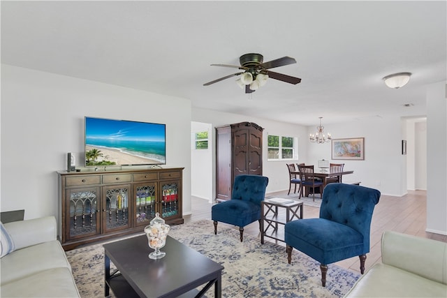 living room with hardwood / wood-style floors and ceiling fan with notable chandelier