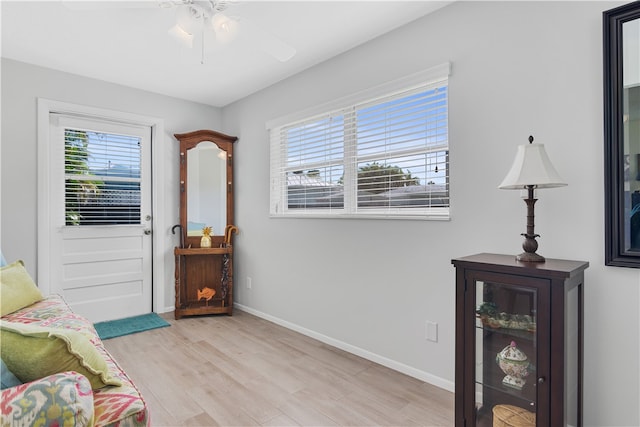 sitting room with light wood-type flooring, a wealth of natural light, and ceiling fan