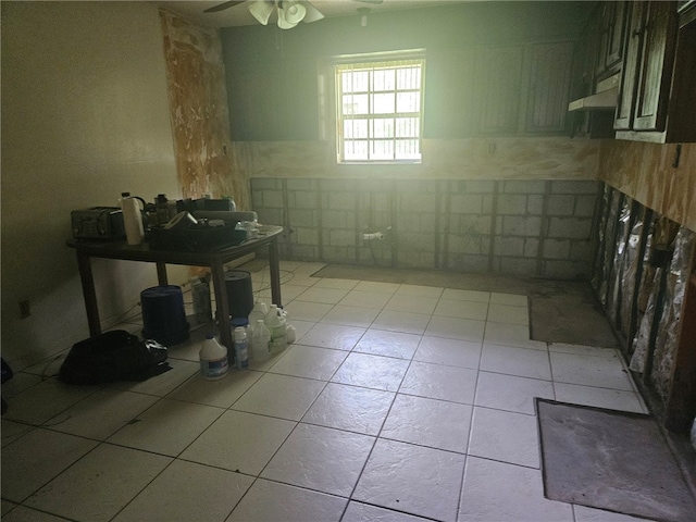 bathroom with ceiling fan, tile patterned floors, and tile walls