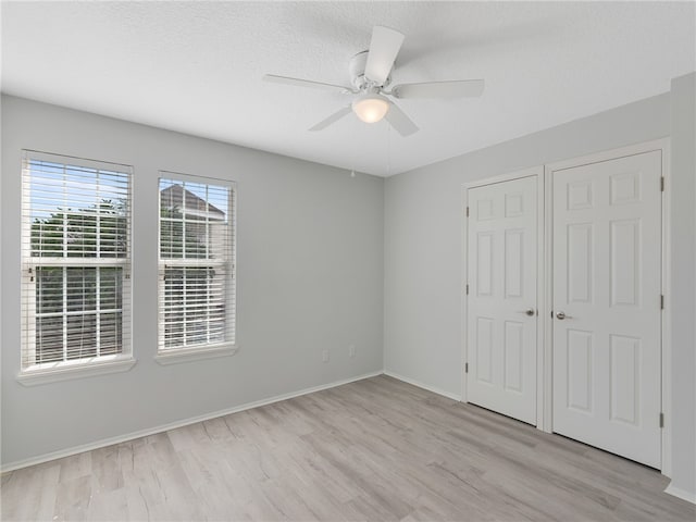 unfurnished bedroom with ceiling fan and light hardwood / wood-style flooring