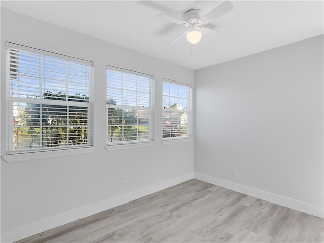 spare room featuring ceiling fan, a healthy amount of sunlight, and light hardwood / wood-style floors