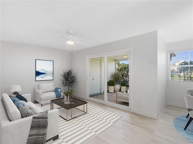 living room featuring ceiling fan and light hardwood / wood-style floors