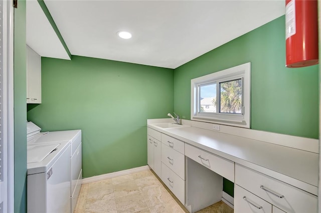 washroom featuring sink, washing machine and clothes dryer, and cabinets