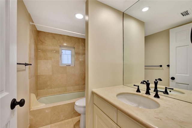 full bathroom featuring tile patterned floors, toilet, tiled shower / bath combo, and vanity