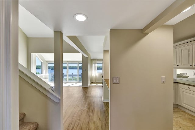 hall featuring light hardwood / wood-style floors and a water view