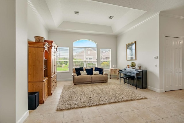 living room featuring a tray ceiling and light tile patterned flooring