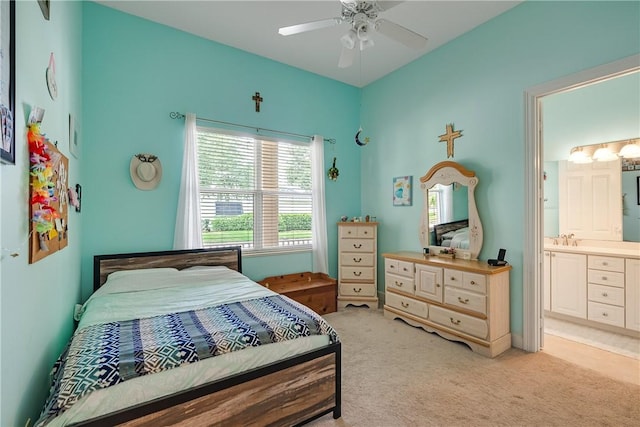 carpeted bedroom with ceiling fan, ensuite bath, and sink