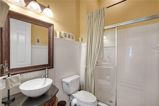 bathroom featuring vanity, a shower with door, and toilet