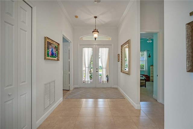 tiled entryway with crown molding and french doors