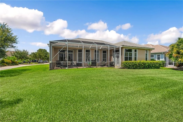 back of property with a lanai and a lawn