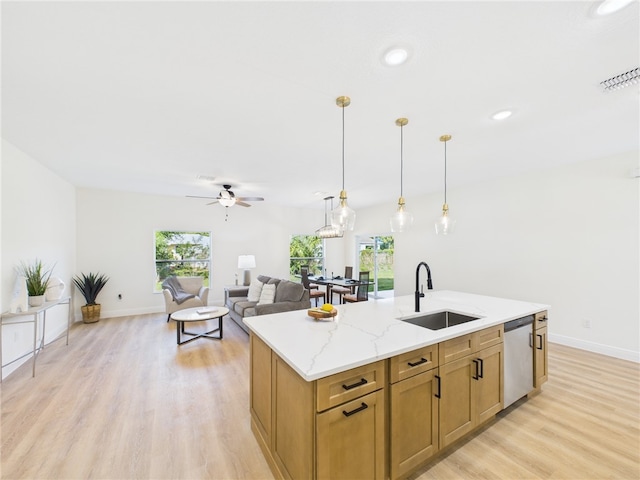 kitchen with light wood-style floors, ceiling fan, stainless steel dishwasher, a sink, and decorative light fixtures