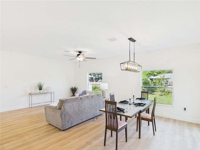 dining area featuring light wood finished floors, visible vents, baseboards, and ceiling fan