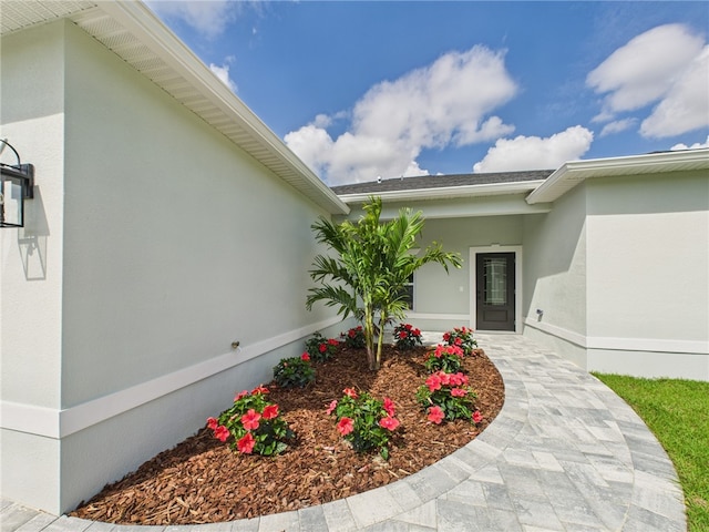 entrance to property featuring stucco siding