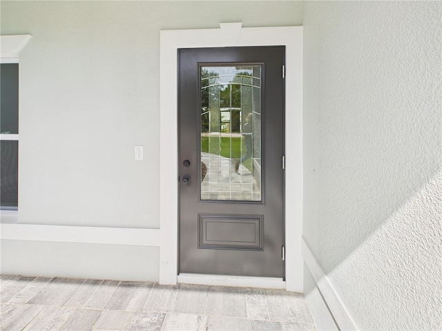 view of exterior entry with stucco siding