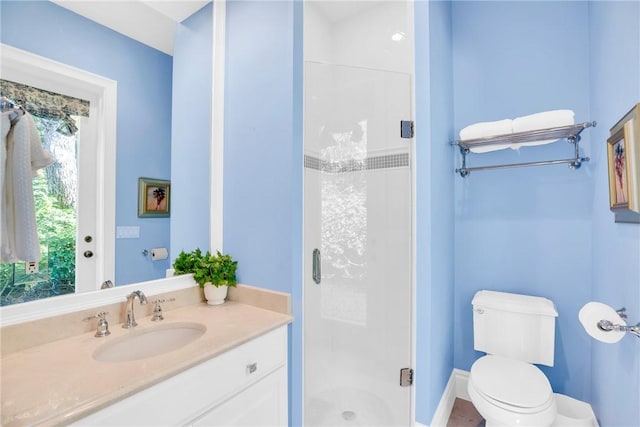 full bathroom featuring a stall shower, vanity, and toilet