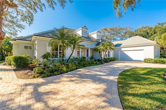 view of front of house featuring a garage, decorative driveway, and stucco siding