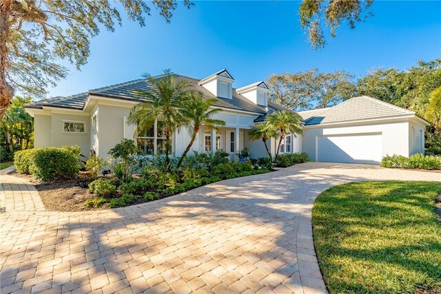 351 Marbrisa Dr, Vero Beach, FL 32963 - view of front of property with stucco siding, an attached garage, decorative driveway, and a tiled roof