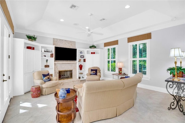 living room with recessed lighting, a large fireplace, visible vents, a tray ceiling, and crown molding