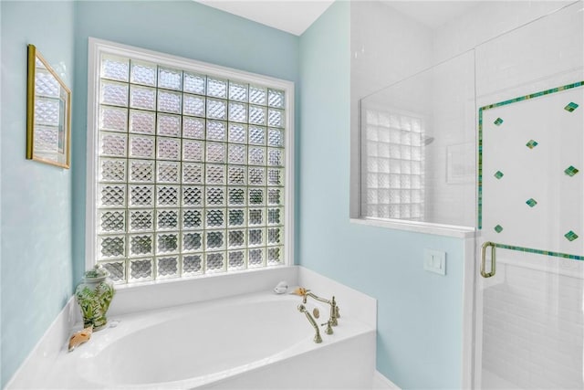 full bath with a stall shower, a garden tub, and a wealth of natural light