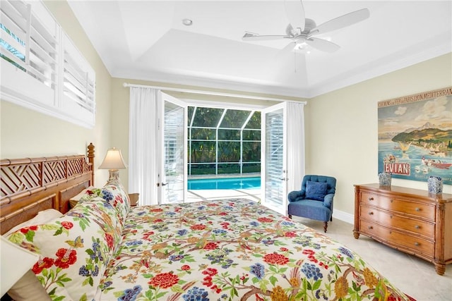 bedroom featuring access to exterior, a sunroom, multiple windows, and a raised ceiling