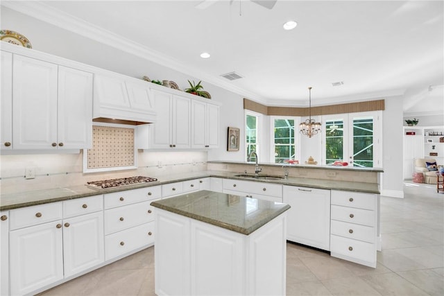 kitchen with visible vents, ornamental molding, a peninsula, stainless steel gas stovetop, and a sink