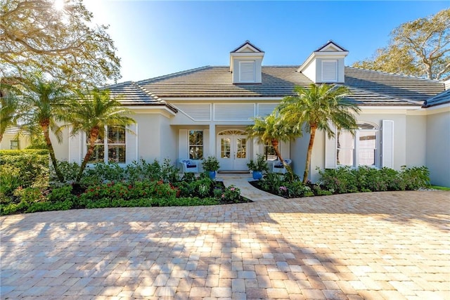 view of front of property featuring a tiled roof, french doors, and stucco siding