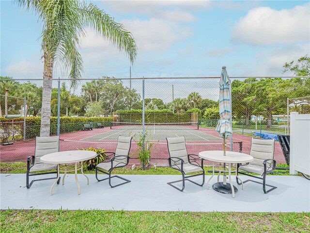 view of property's community featuring a patio and tennis court