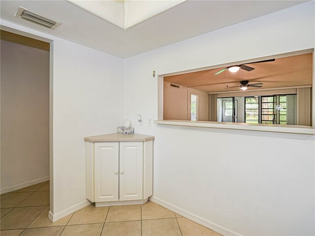 interior space featuring light tile patterned flooring and ceiling fan