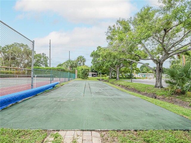 view of home's community with tennis court