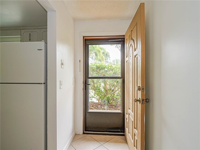 entryway featuring a textured ceiling and light tile patterned floors