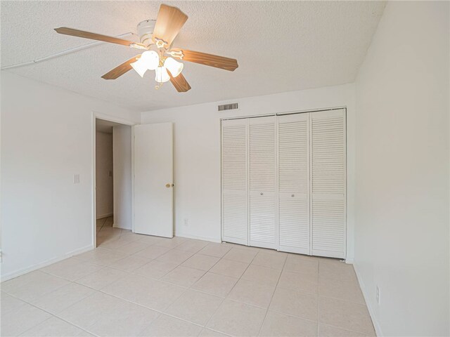 unfurnished bedroom featuring ceiling fan, a textured ceiling, and a closet