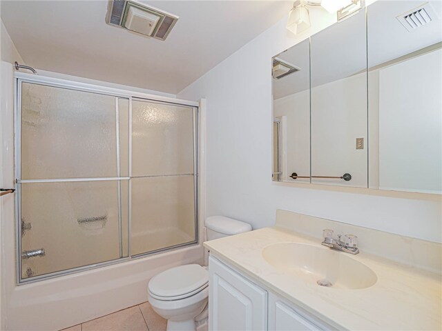 full bathroom featuring toilet, vanity, tile patterned flooring, and enclosed tub / shower combo